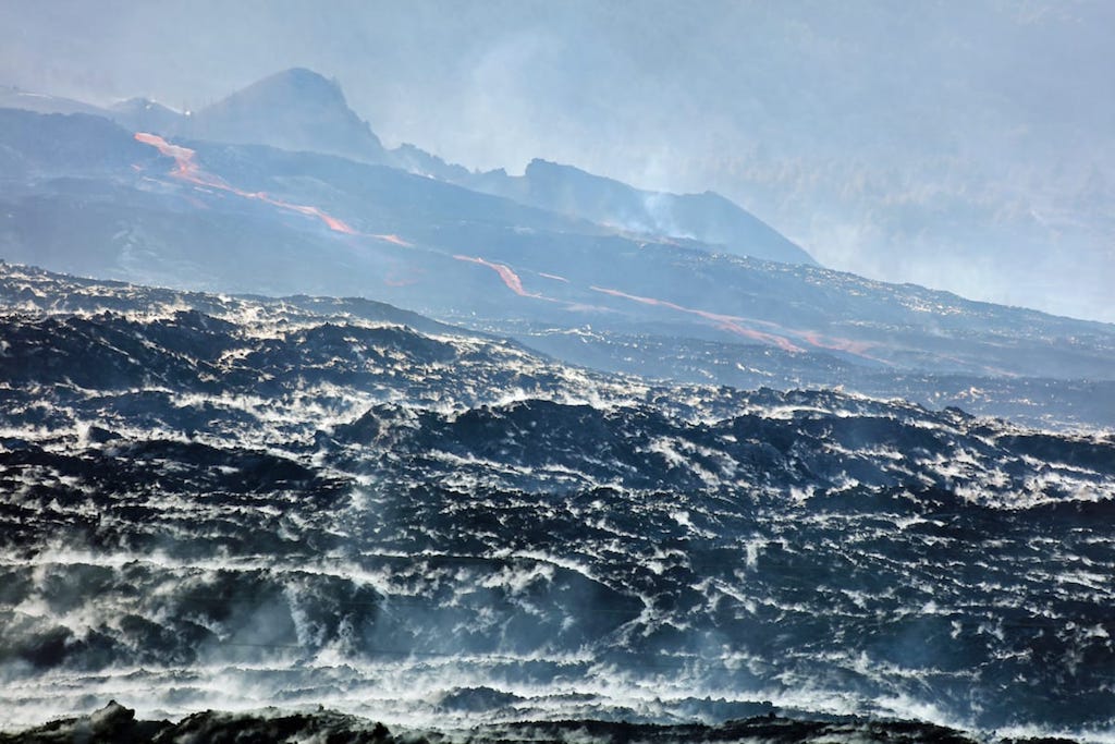 El volcán sigue vomitando lava y amenaza en dos frentes