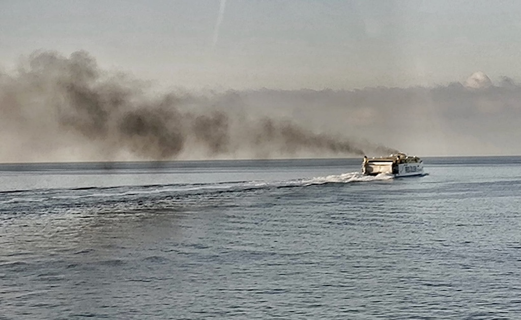 El catamarán “Barlovento Express”, de Fred. Olsen, navega “bajo negro palio de humo”